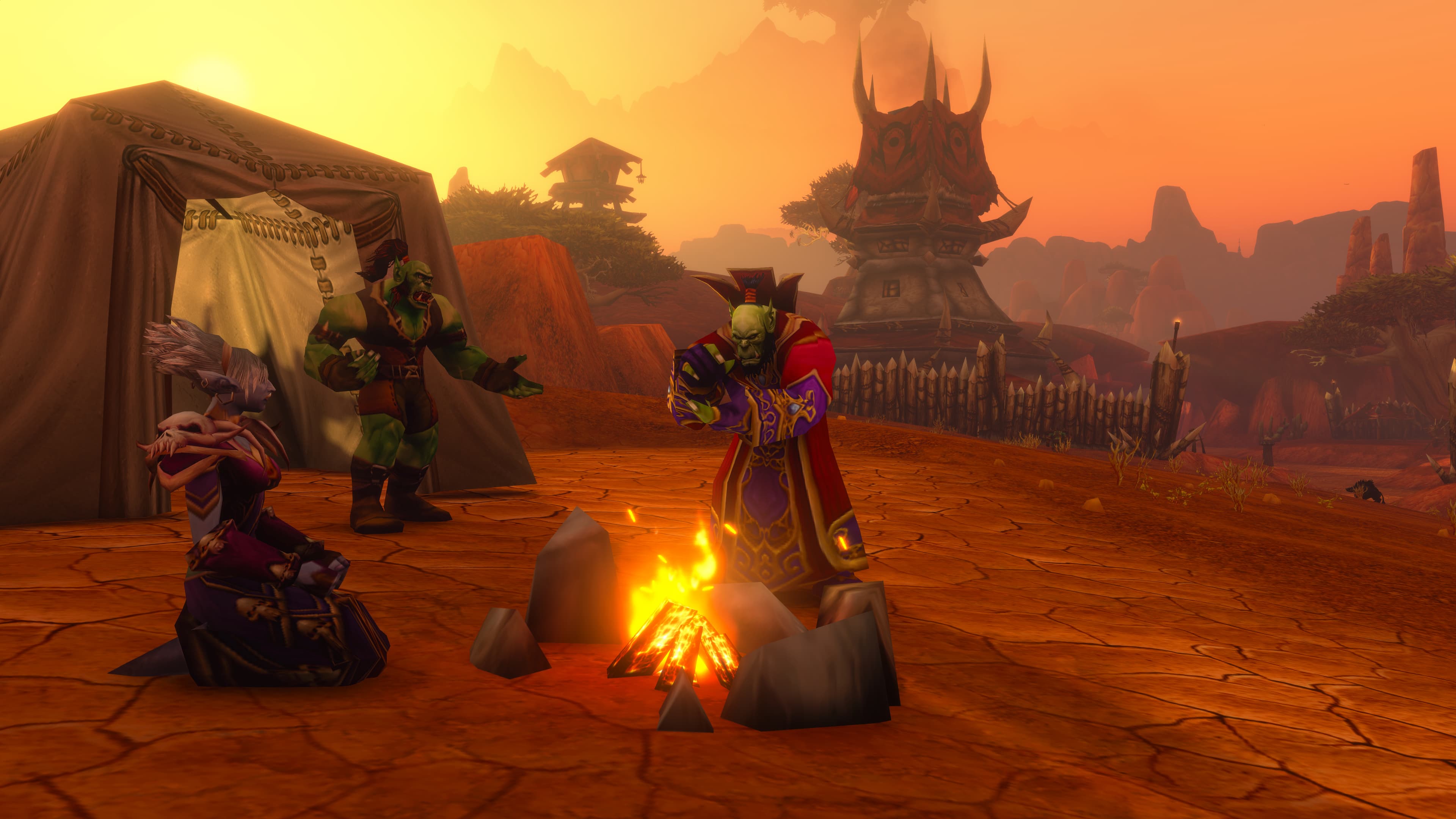 Horde adventurers around a campfire at sunset, with a tent and a spiked tower behind them.